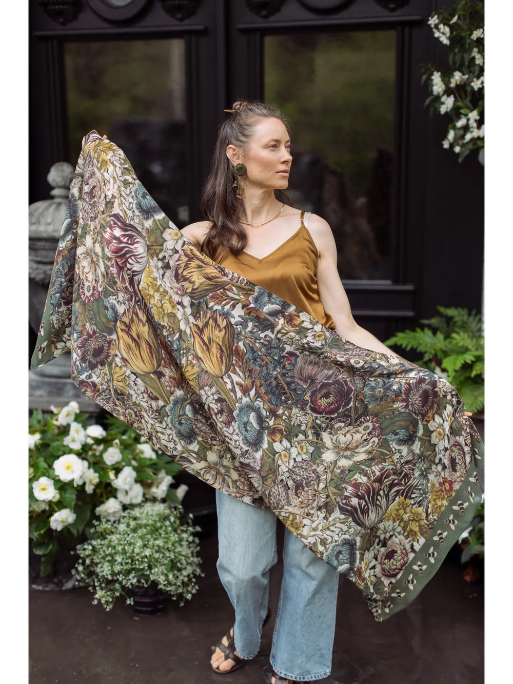 A woman holding the Love Grows Wild Floral Bamboo Scarf with Bees by Market of Stars