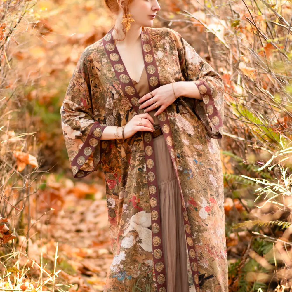 
                      
                        A woman standing outside while wearing the Dreamweaver Zodiac Kimono Duster Robe by the brand Market Of Stars
                      
                    