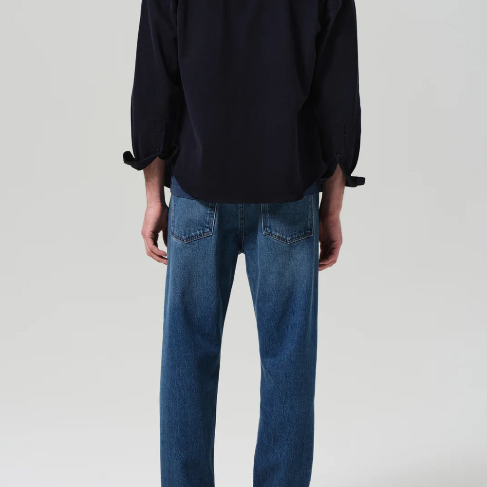 
                      
                        Person wearing a black shirt and blue jeans with a relaxed, tapered fit
                      
                    