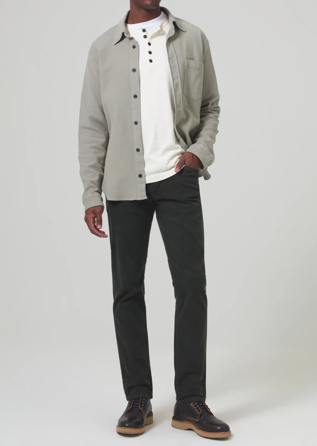 A man wearing the Dark Green Gage Slim Straight Corduroy men's pants by Citizens Of Humanity