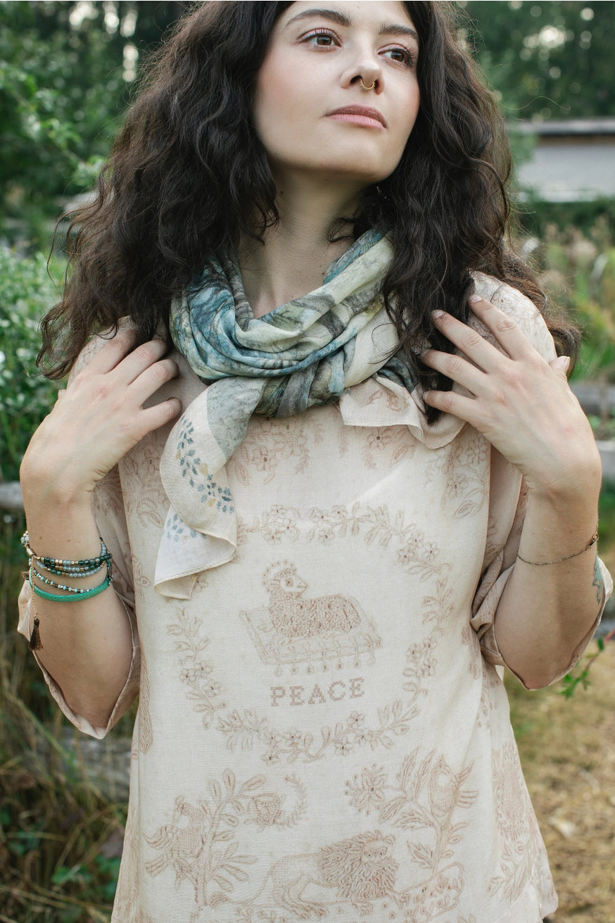 A woman modeling the Land Of Plenty Bamboo Scarf by Market of Stars tied around her neck