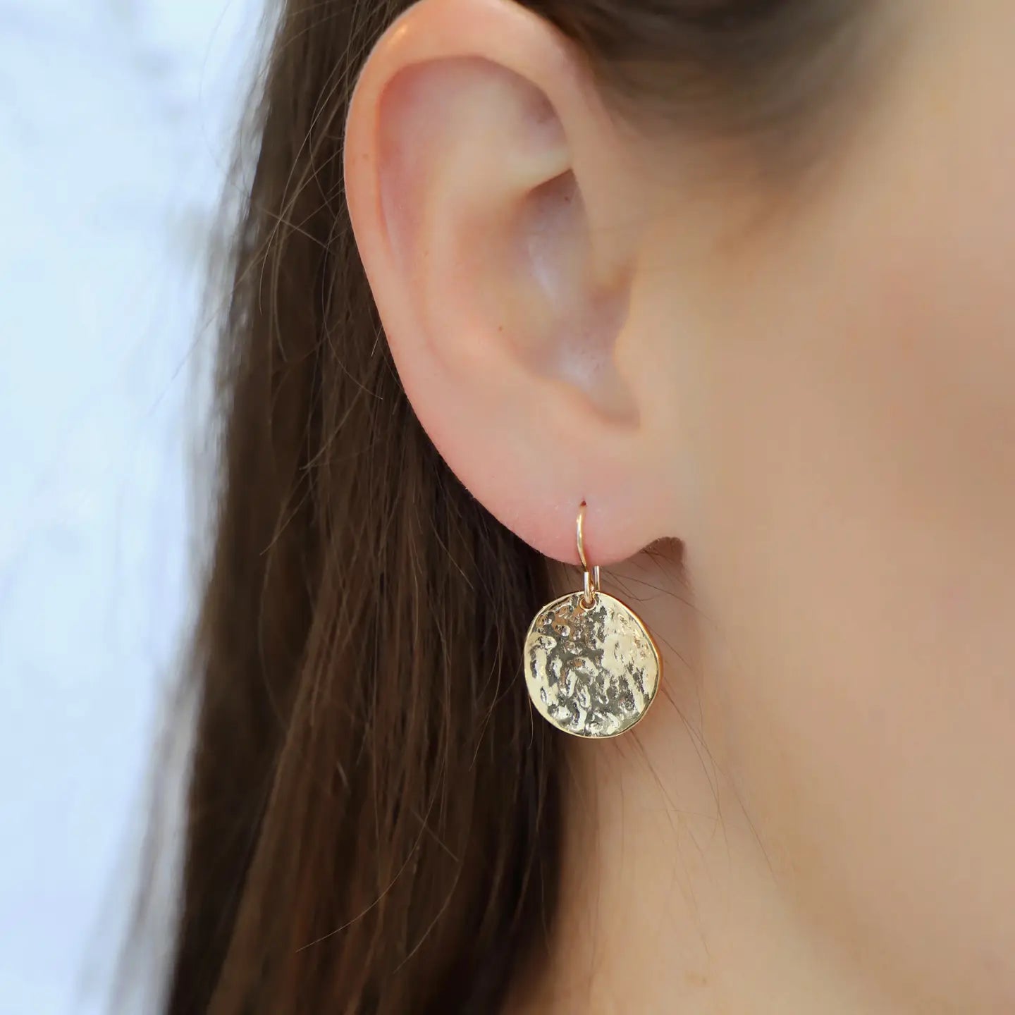 Woman wearing the Gold Hammered Medallion Earrings by Katie Waltman Jewelry