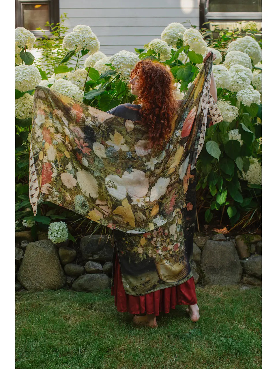 A woman holding the I Dream in Flowers Bohemian Bamboo Scarf with Bees by Market of Stars