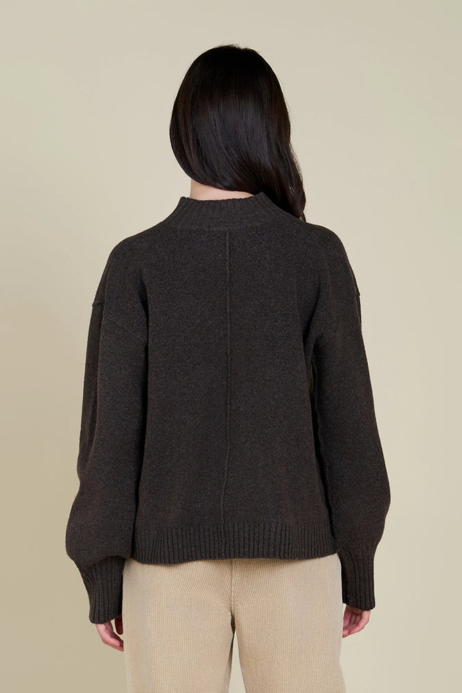 
                      
                        Women's dark brown relaxed fit turtleneck with exposed seaming detail. 
                      
                    