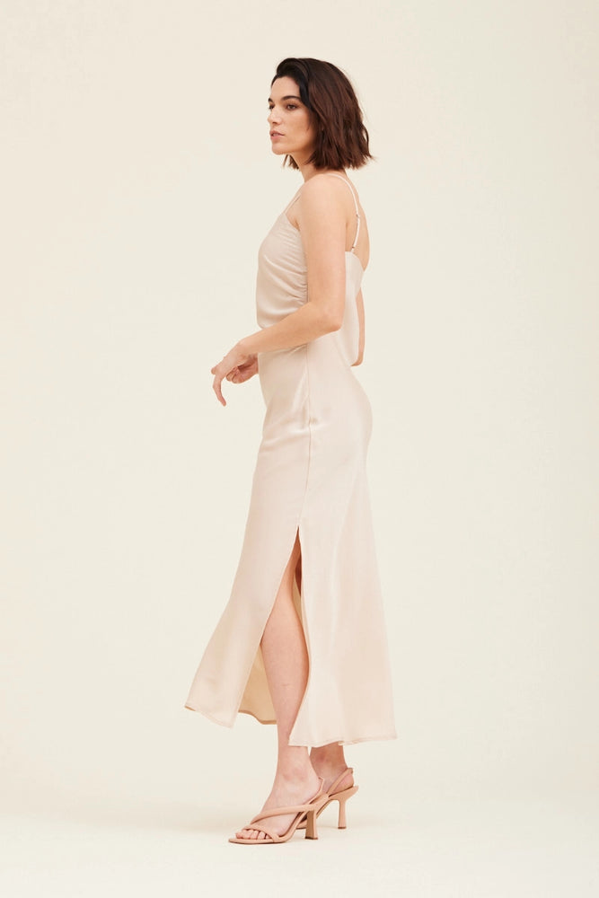 
                      
                        Side view of an ecru colored gathered side midi slip dress 
                      
                    