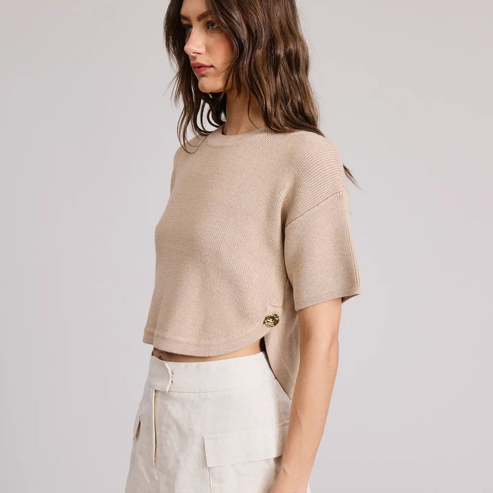 Woman wearing a beige cropped sweater with button detail by Flat White