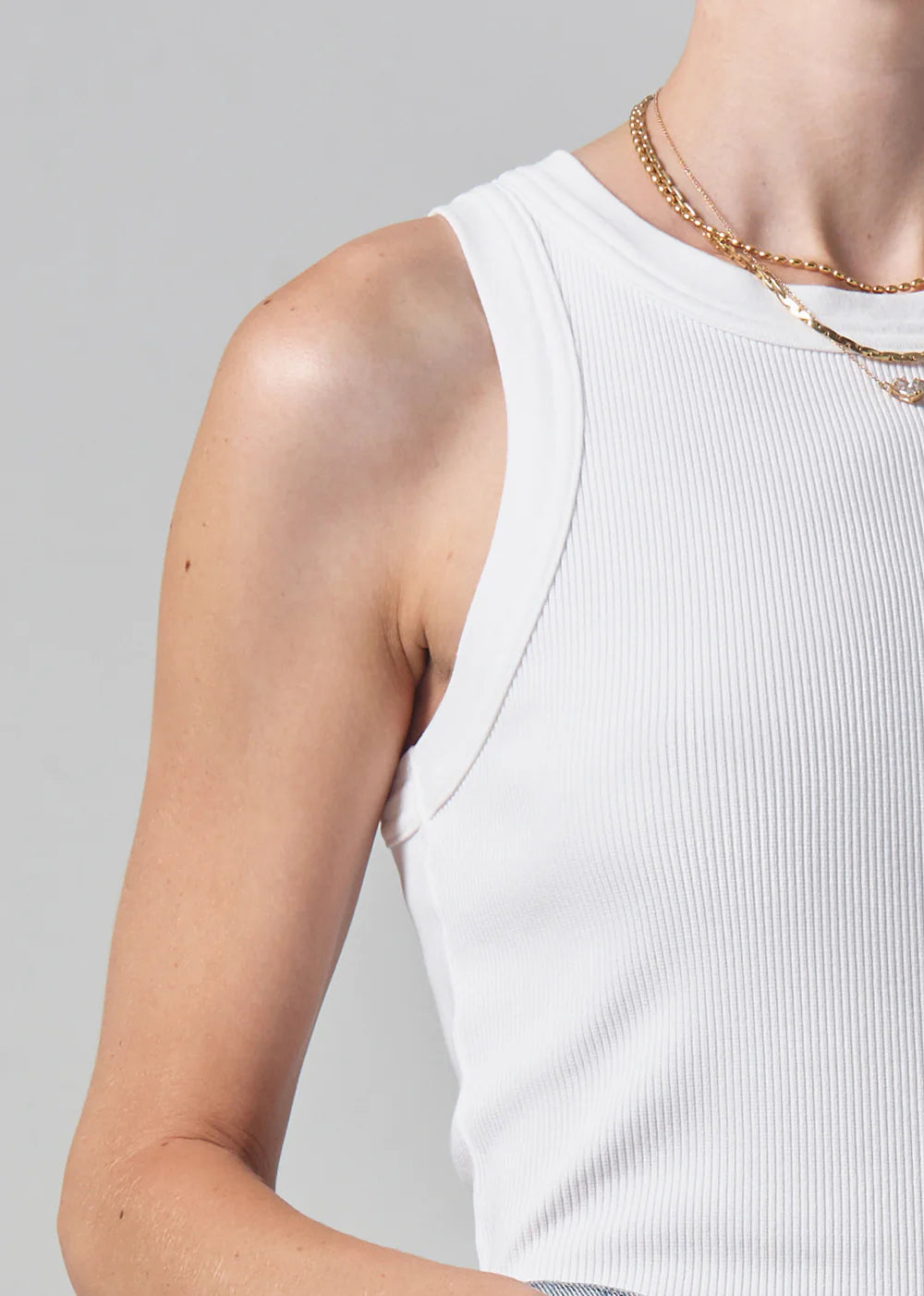 Closeup front detailed view of model wearing a white ribbed tank by Citizens of Humanity