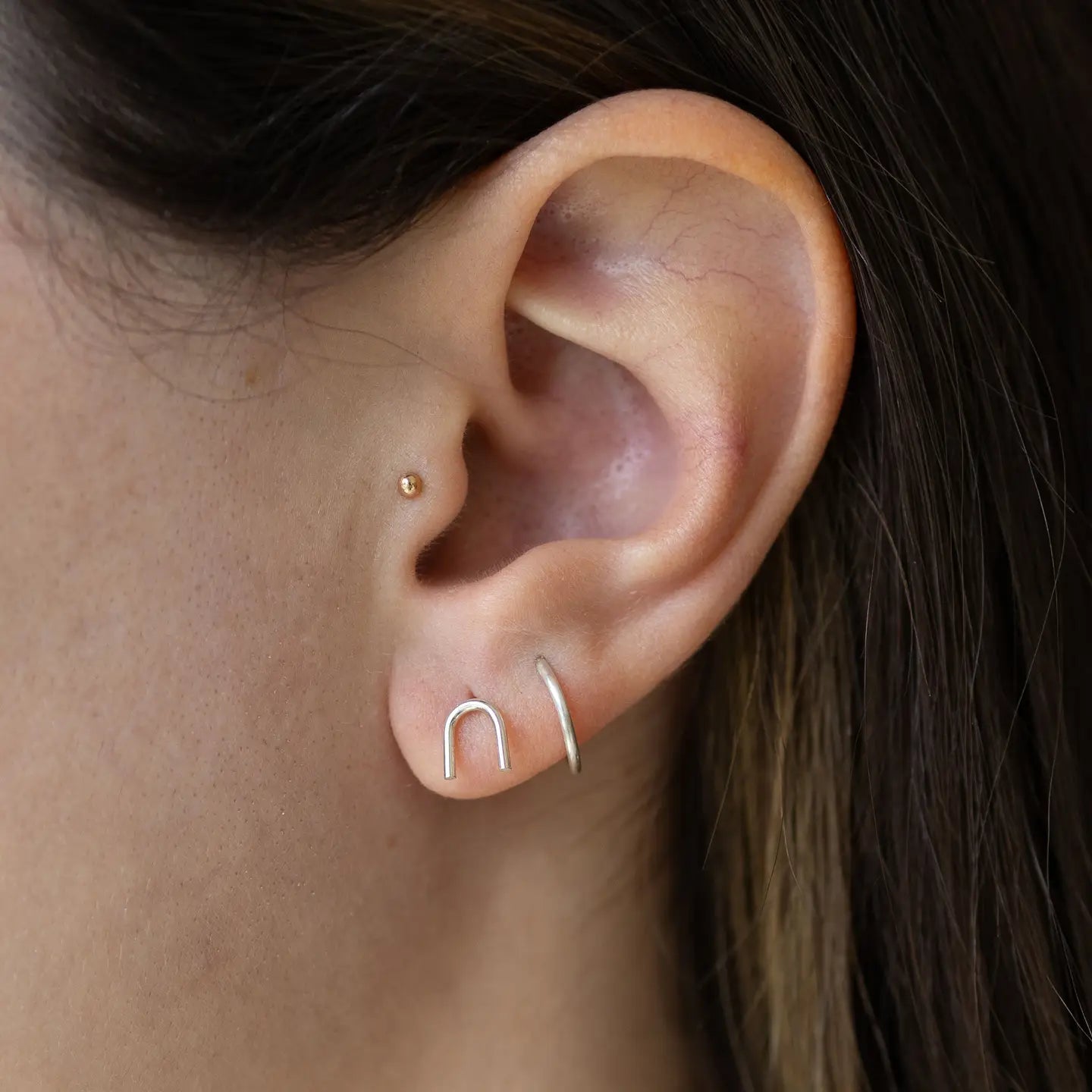 Woman wearing the Sterling Silver Arch Stud Earrings by The Land Of Salt