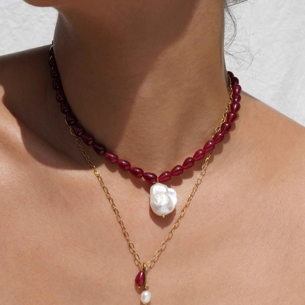 A person wearing the Geras Necklace by KOZAKH layered with a complimentary chain necklace