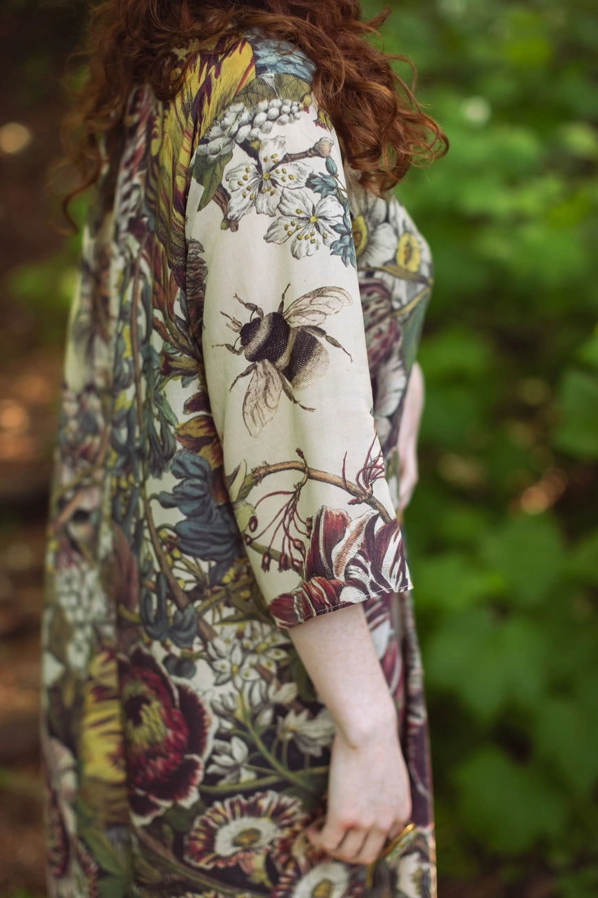 Person wearing a patterned garment with a bumblebee design in a natural setting