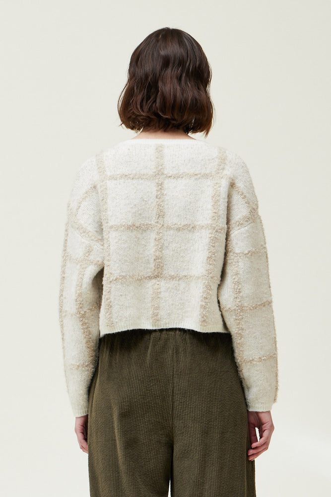 Back view of a woman wearing an Ivory Cropped Grid Sweater 