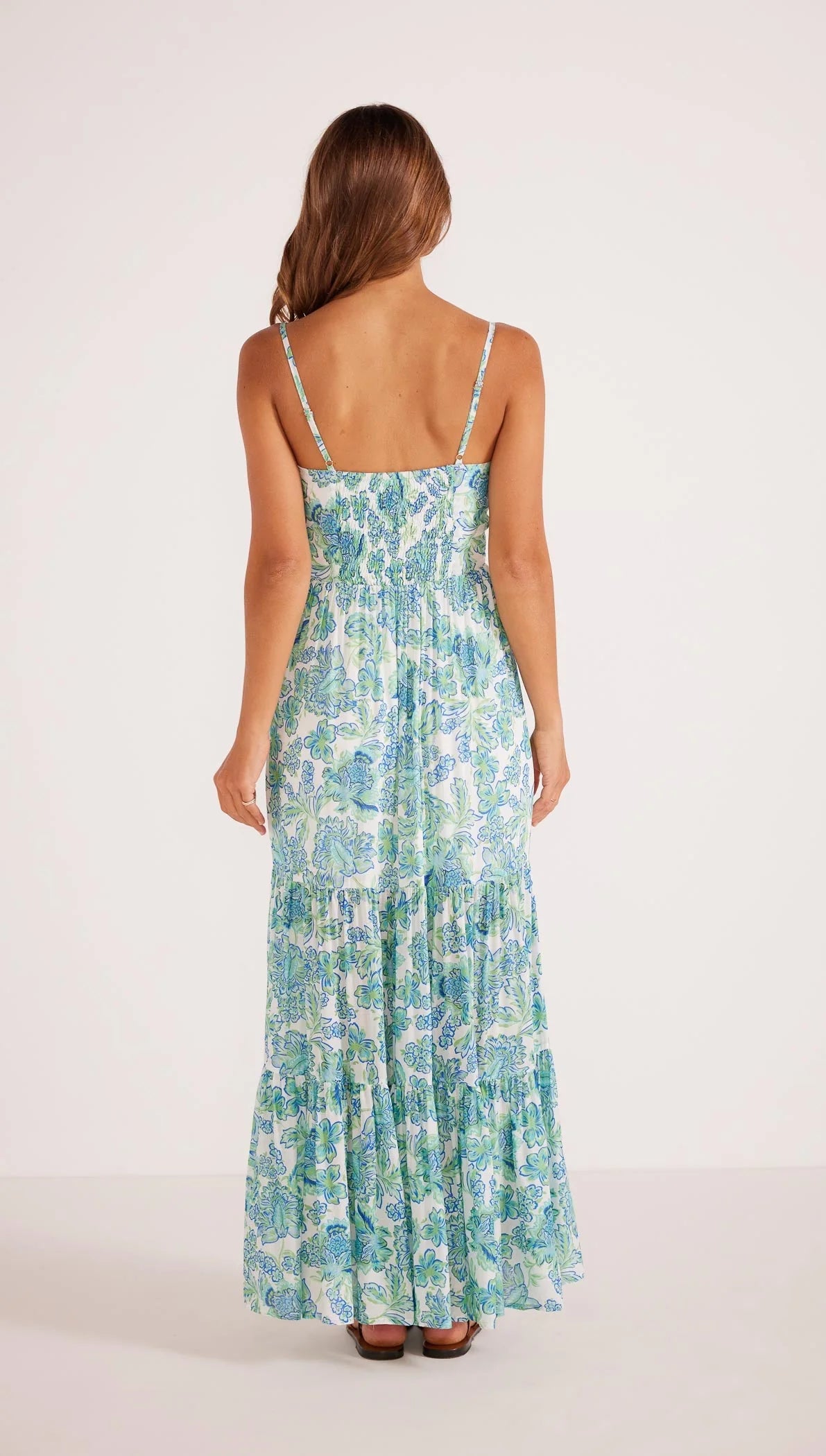 Back view of the blue and green floral Aessia Tiered Maxi Dress by MINKPINK