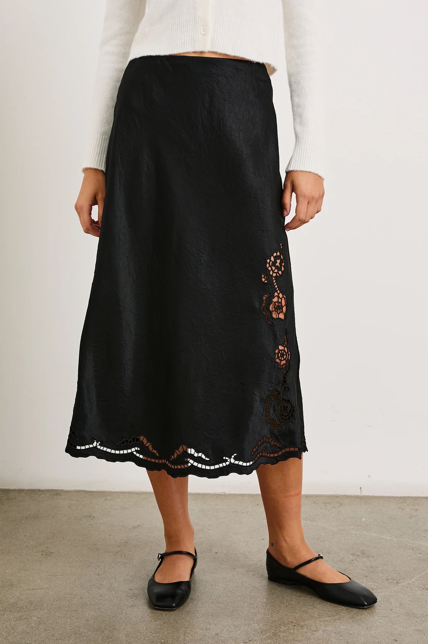 Front view of a woman wearing the Black Eyelet Anya Skirt by the brand Rails.