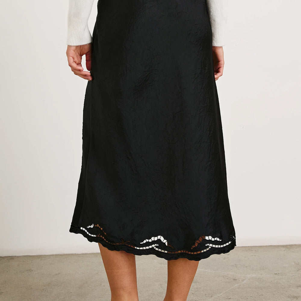 
                      
                        Back view of a woman wearing the Black Eyelet Anya Skirt by the brand Rails.
                      
                    