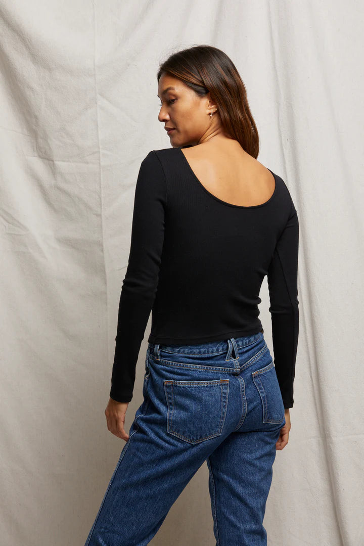 Person wearing a black long-sleeve top from Perfect White Tee 