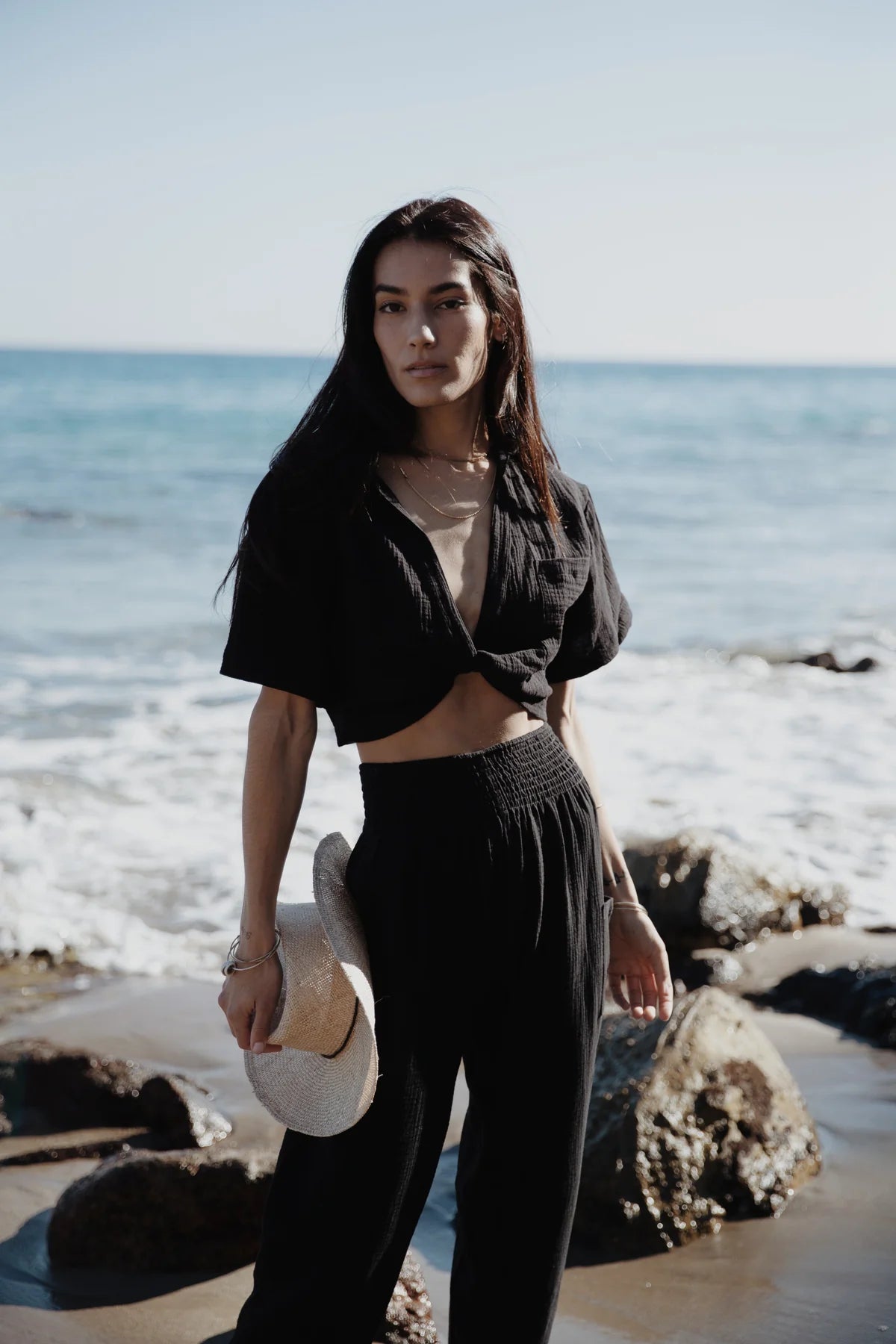 Woman at the beach wearing Stillwater's Easy Cargo Beach Pant in the color Black