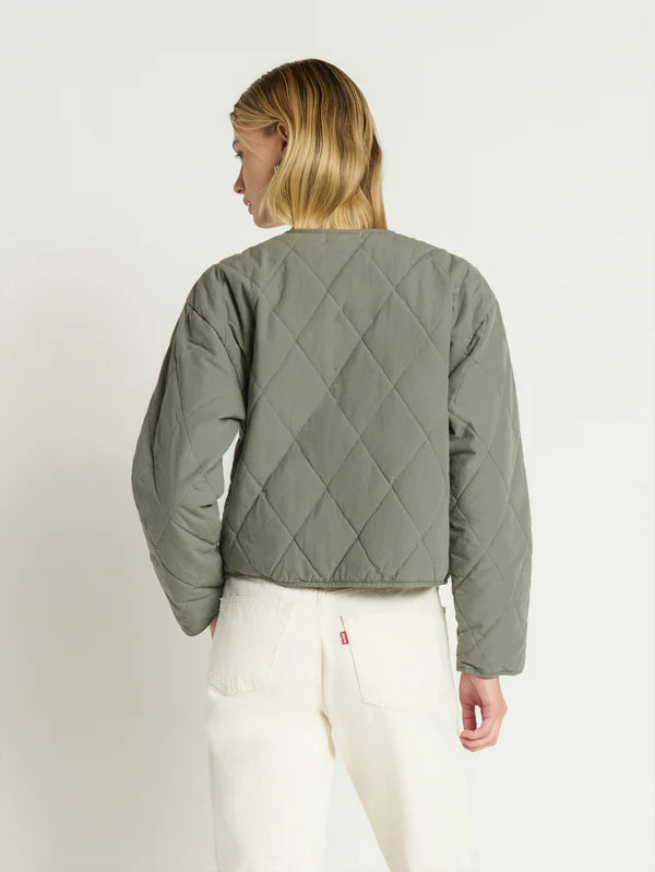 Person wearing a green quilted jacket 