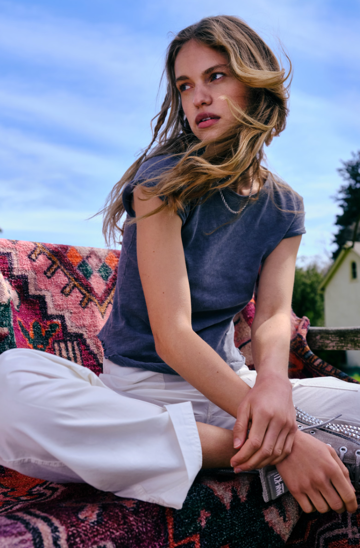 A woman sitting outside while wearing the Black Be My Baby Tee by Free People