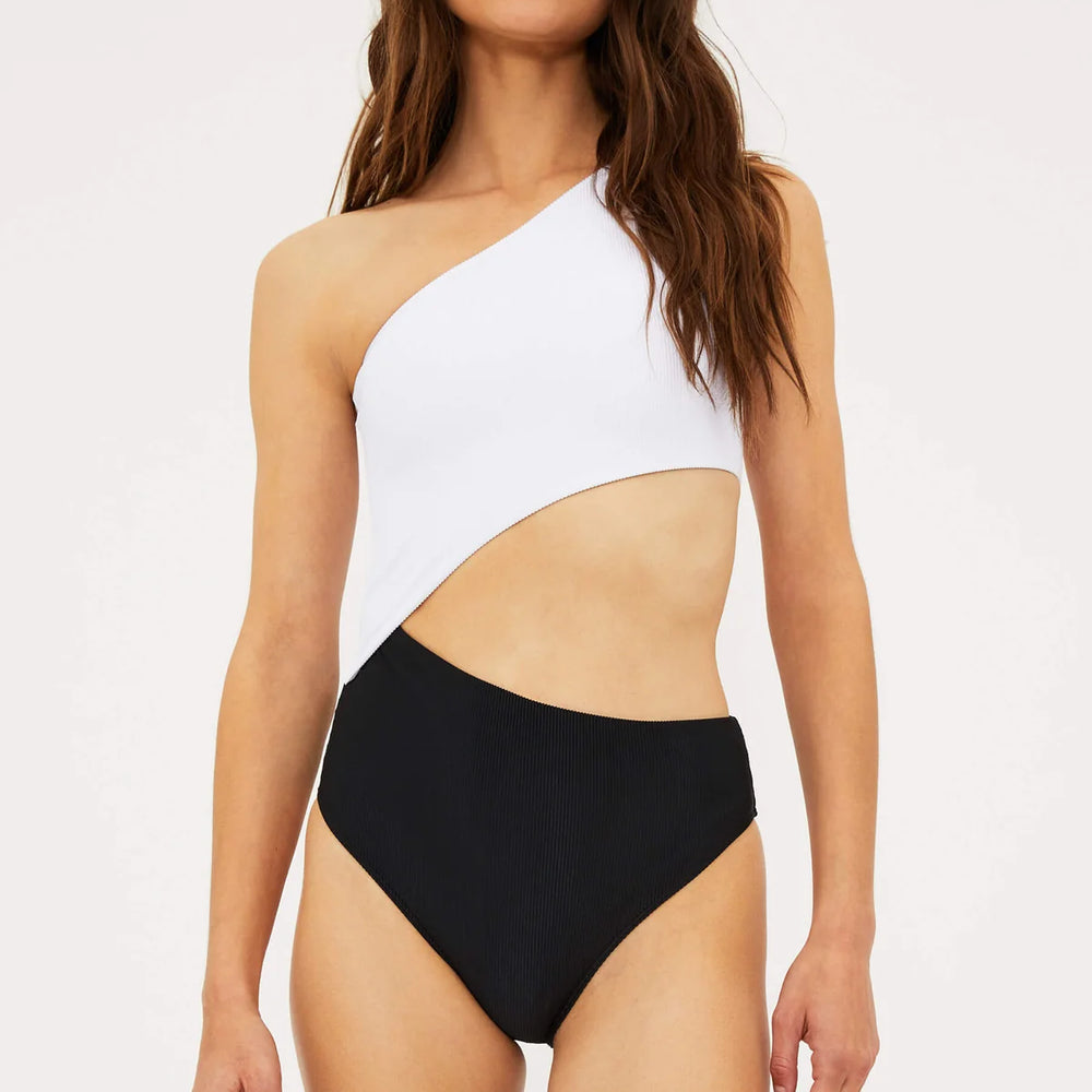 
                      
                        front view of woman wearing a black and white colorblock, asymmetrical one shoulder one piece swimsuit with a side cutout detail.
                      
                    
