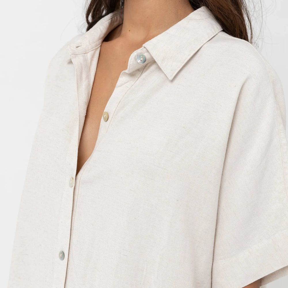 Close up front view of woman wearing an oat color oversized short sleeve shirt dress