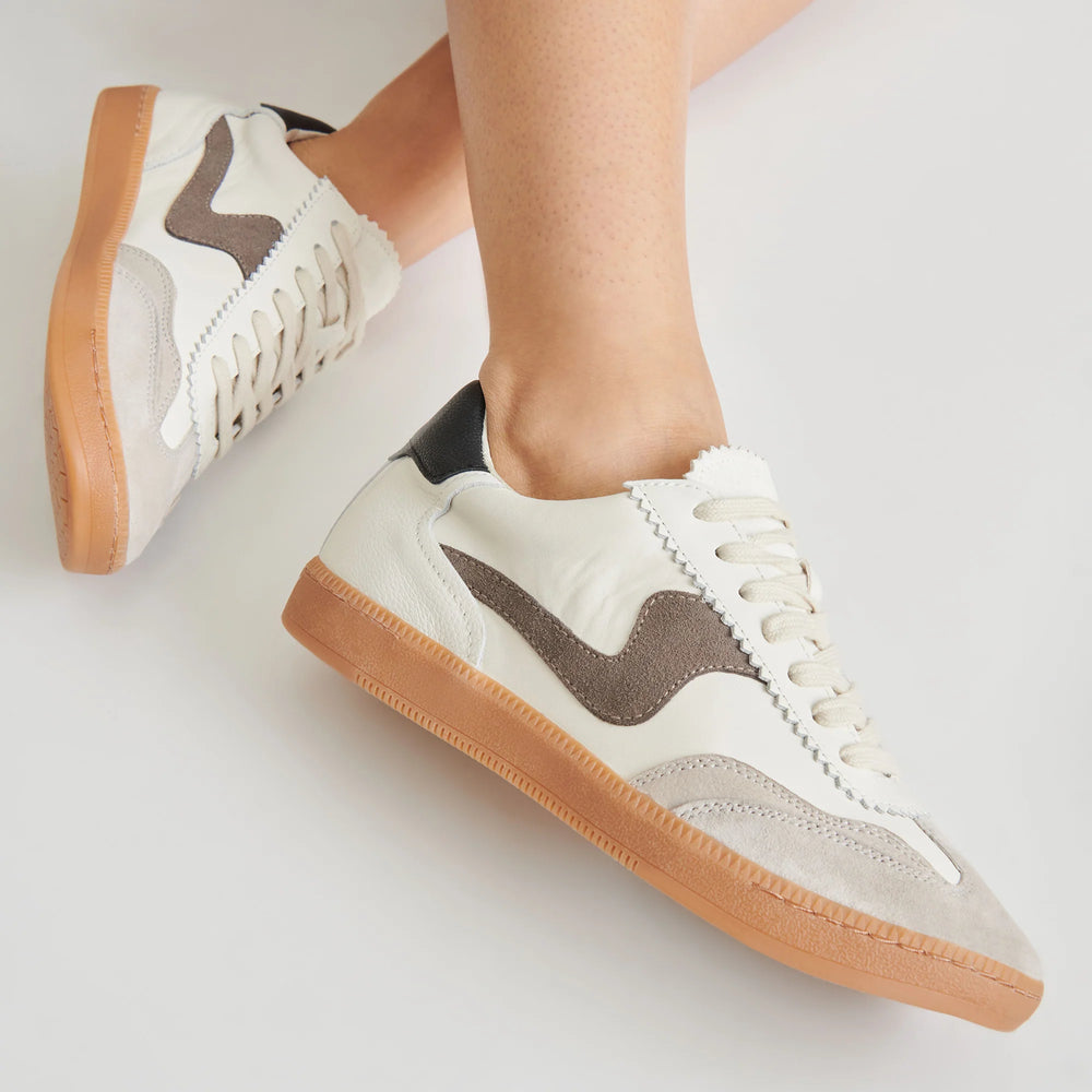 The women's grey and white leather Notice Sneaker by Dolce Vita features a low-top, laceup profile. Shop now at our Harbour Thread location in Burlington, VT!