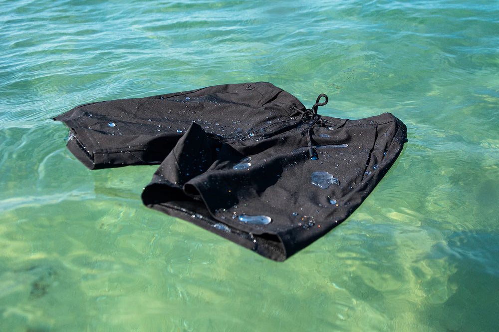 The Black 17" Layover Traveler Shorts by Roark floating in water