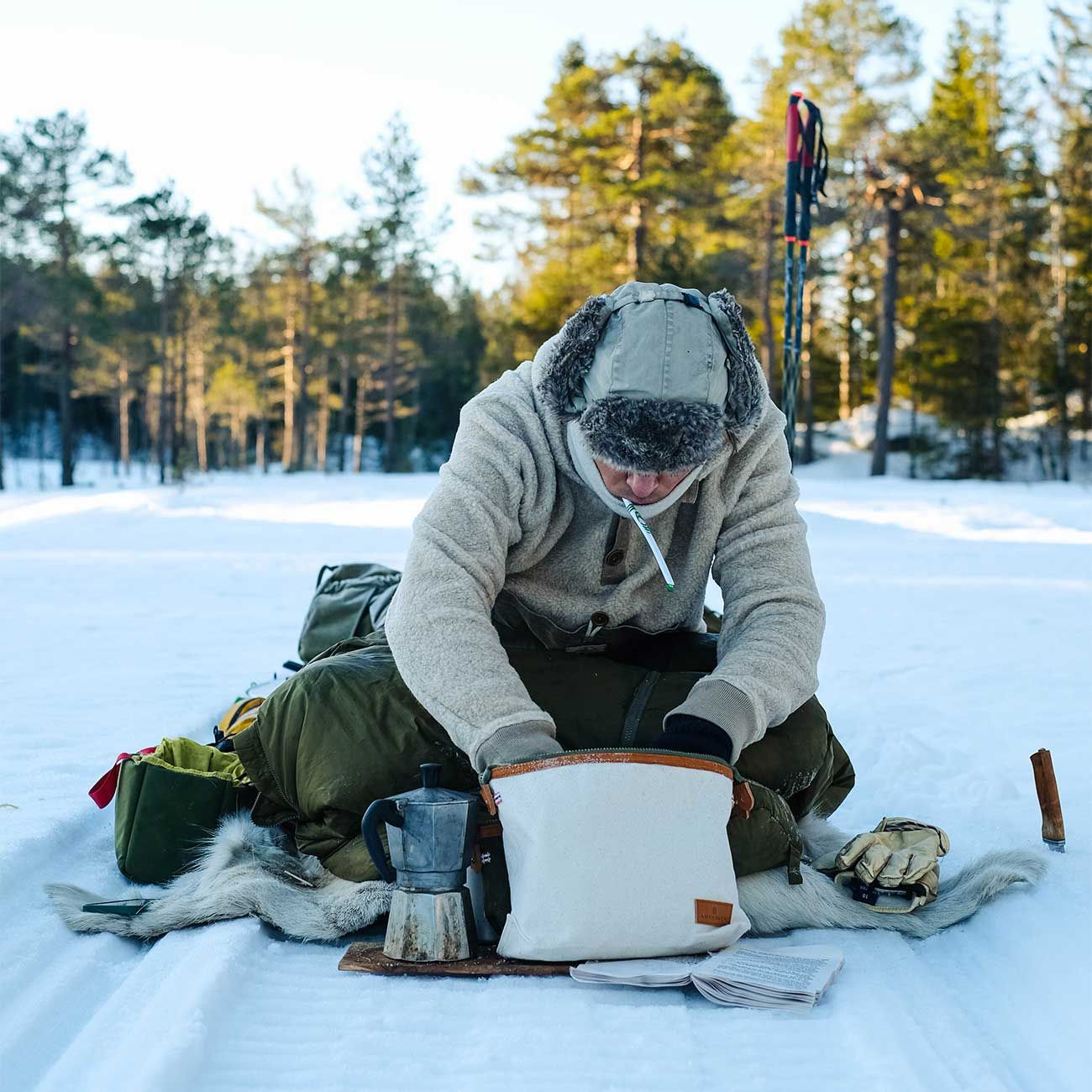 Person in the snow using the Wash Bag travel pouch in the color Natural by Amundsen Sports