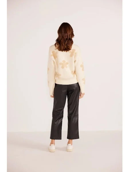 Back view of a woman wearing MINKPINK's Daisy Fluffy Knit Jumper paired with black trousers