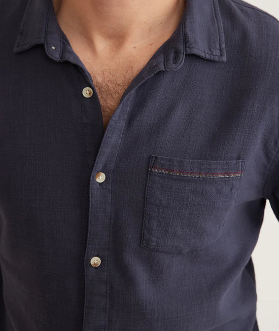 close up view of men's dark blue long sleeve button up shirt showing subtle color detail on front chest pocket