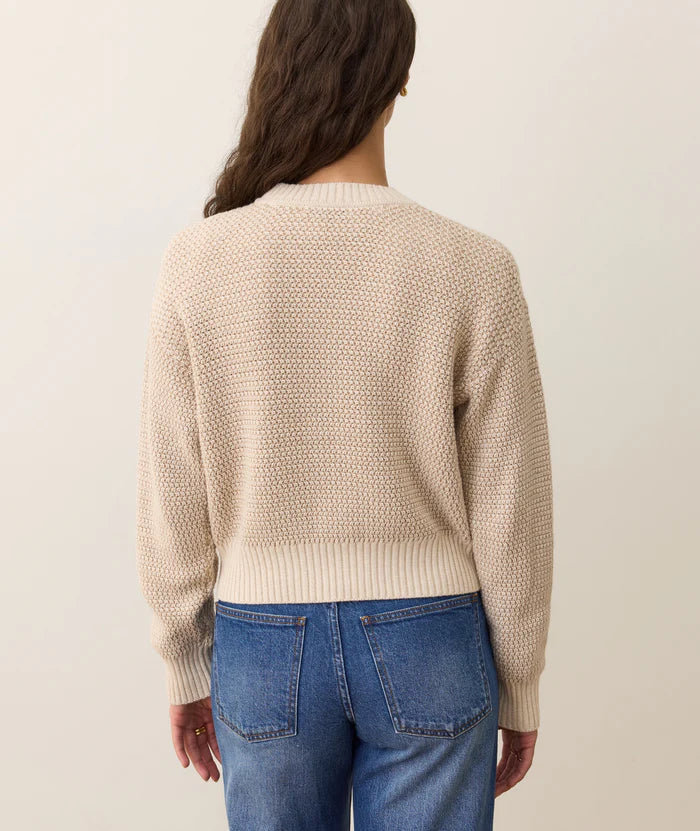 
                      
                        Person wearing a beige knitted sweater and blue jeans on a plain background
                      
                    