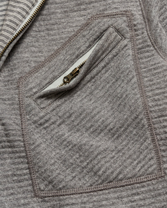 Close up of front zip pocket on a men's grey pullover