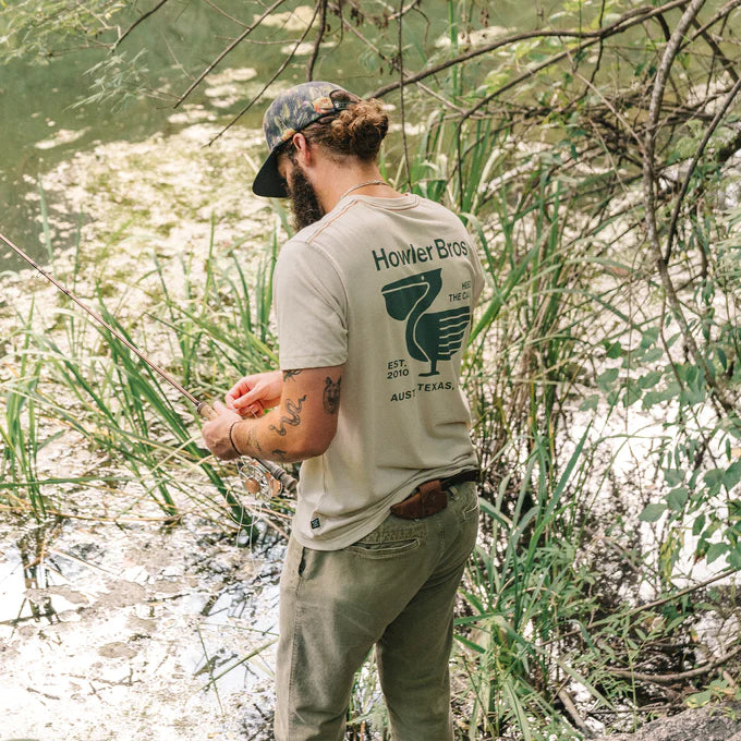 A man outside wearing the Blended Pelican Postage Pocket T-Shirt by Howler Bros