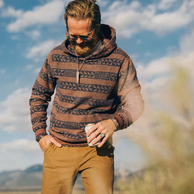 A man outside wearing the Mink Brown Hanko Stripe Tajima Pullover by Howler Brothers
