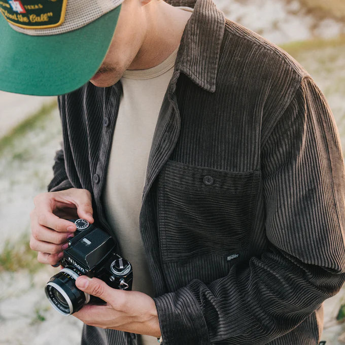 A man holding a camera while wearing the Cocoa Iquitos Overshirt by Howler Brothers