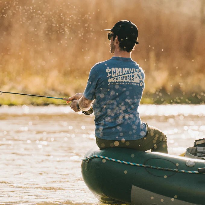 A man fishing while wearing the CC Workshop Pocket T-Shirt by Howler Brothers