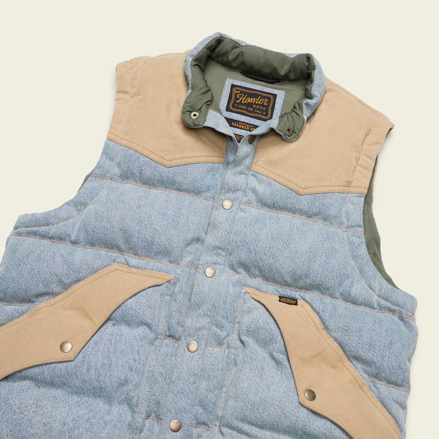 Denim vest with beige accents and 'Howler Bros' branding 