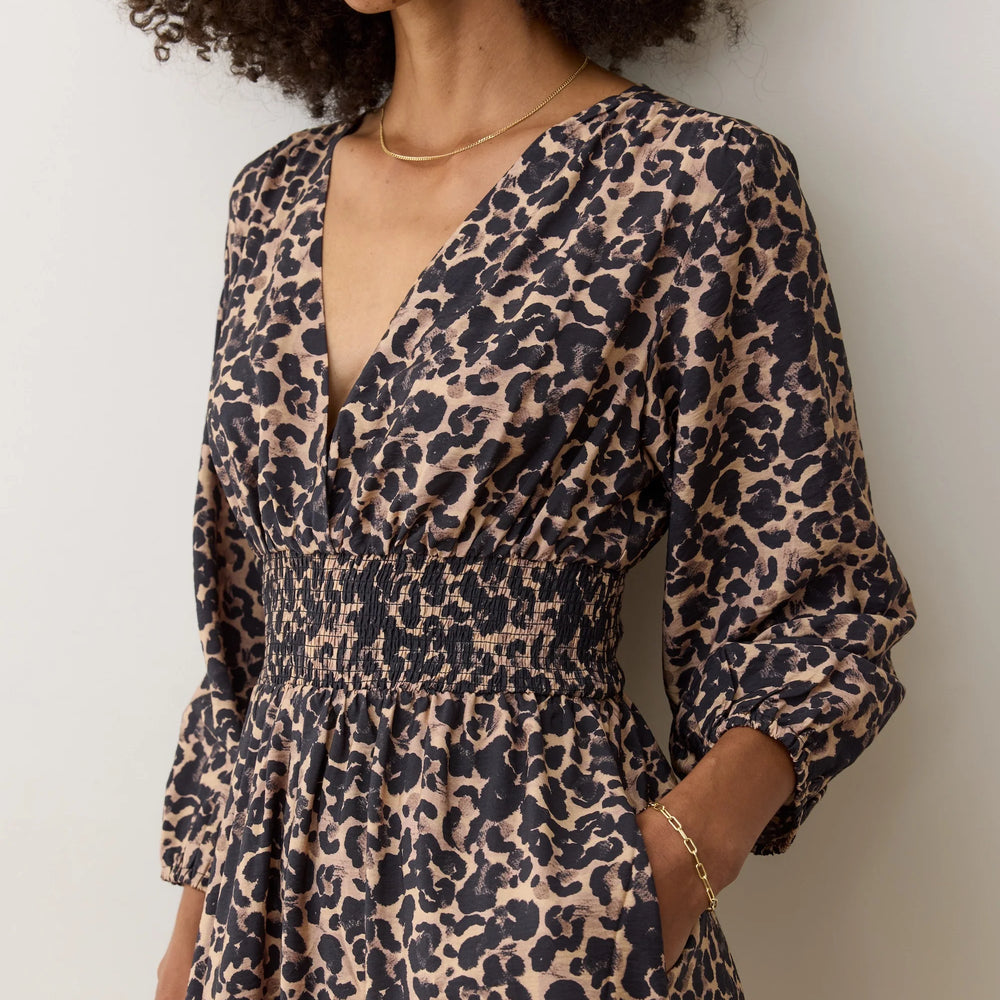 This waist-defining dress offers a flattering fit with smocking, v-neckline and easy-to-wear wrinkle-free fabric. 