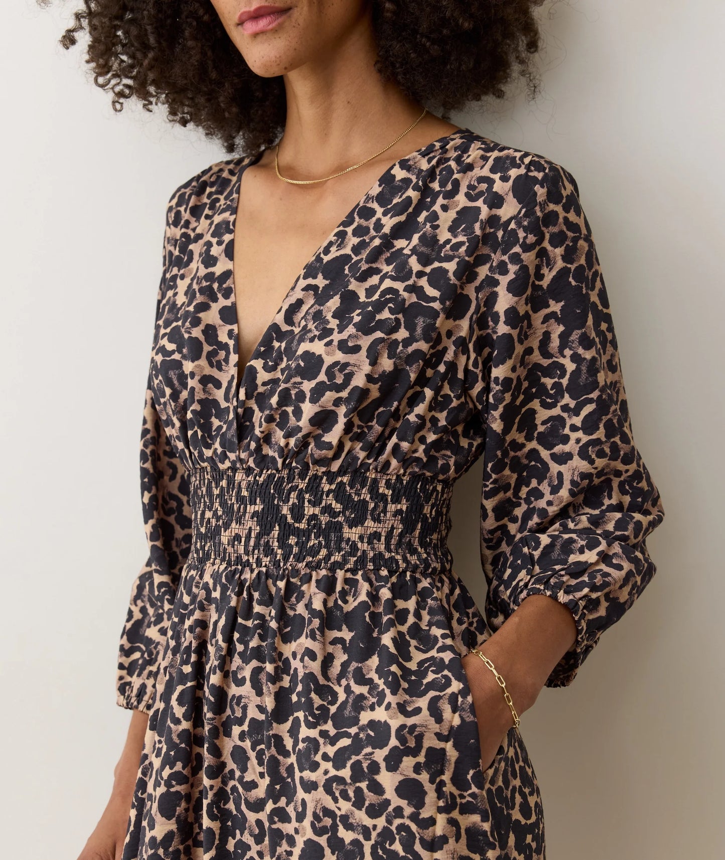 This waist-defining dress offers a flattering fit with smocking, v-neckline and easy-to-wear wrinkle-free fabric. 
