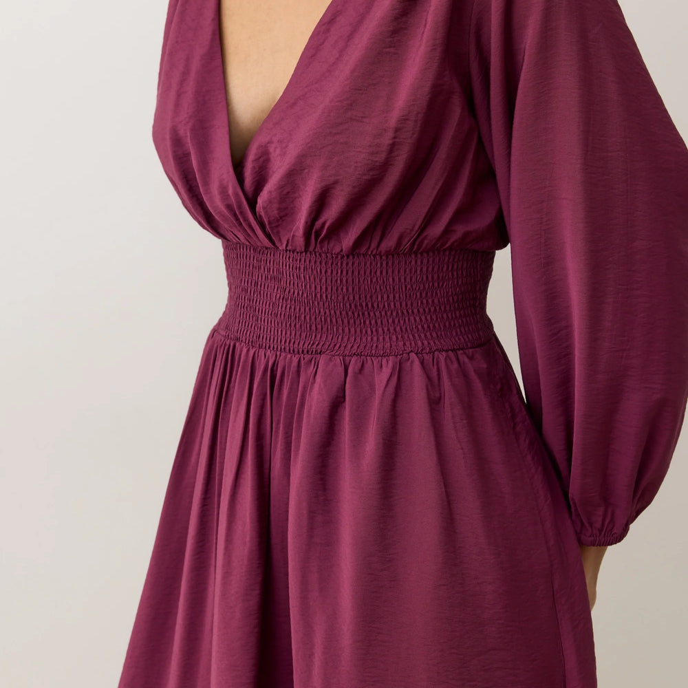 
                      
                        Dress with smocked waist and deep v-neckline
                      
                    