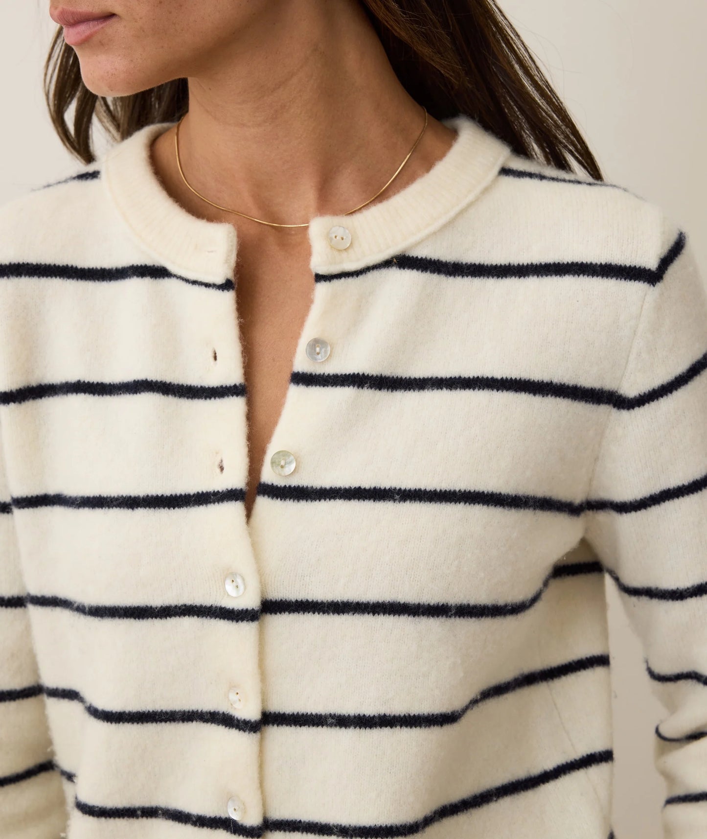 A woman wearing the Marine Layer Sausalito Cardigan in the color Harbour Stripe. 