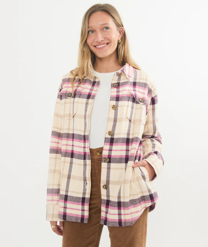A woman wearing the Bailey Flannel Shirt Jacket by Marine Layer. She has it styled unbuttoned, layered over a t-shirt. 