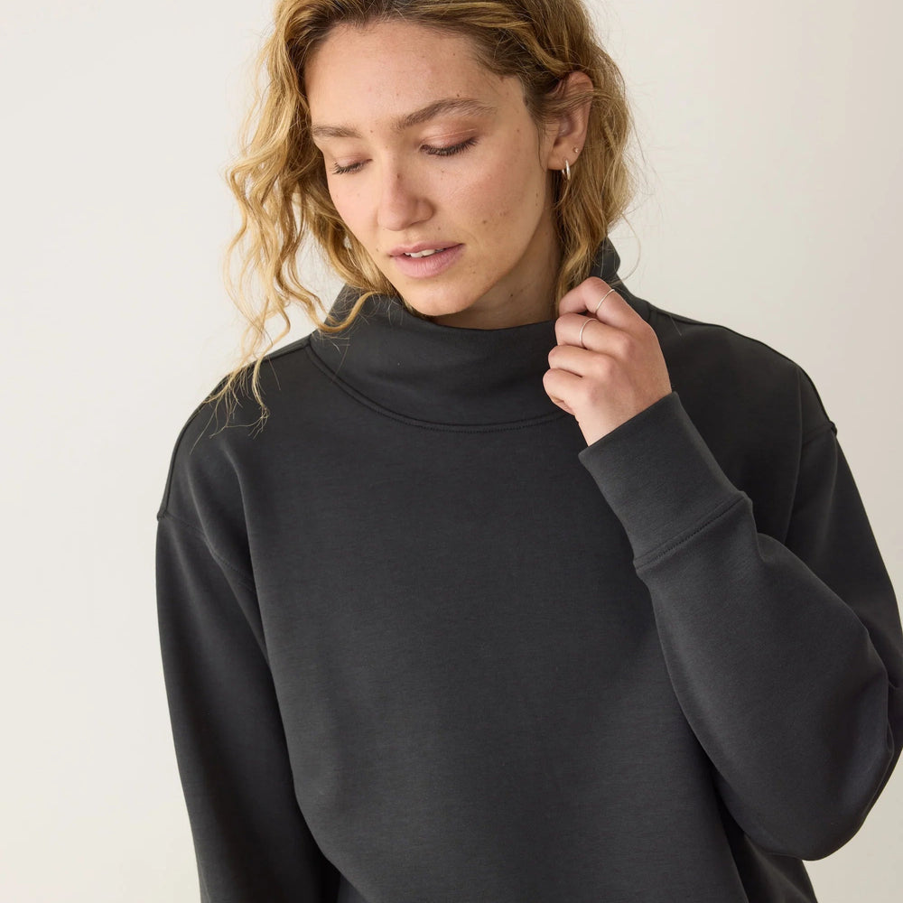 A woman wearing the Marine Layer Nova Mock Neck Sweatshirt in the color Black