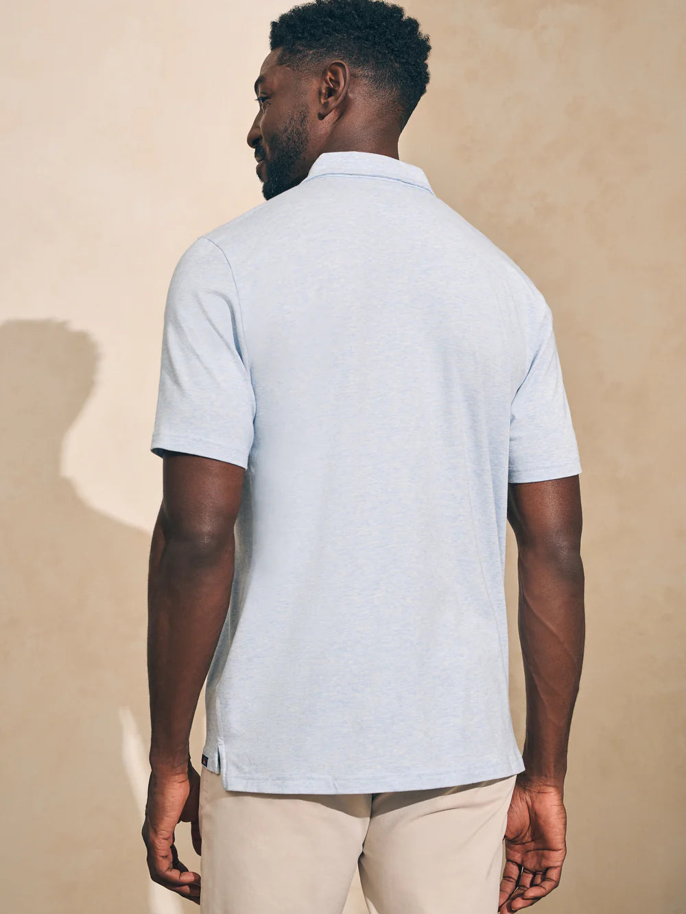 Back view of Faherty's Short Sleeve Movement Polo in the color Cardiff Blue Heather