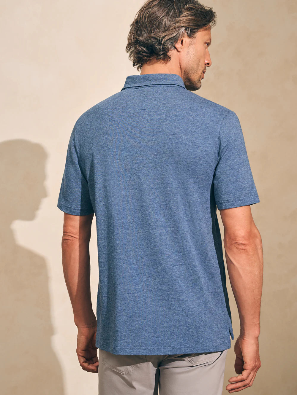 Back view of Faherty's Short Sleeve Movement Polo in the color Sea Navy Melange