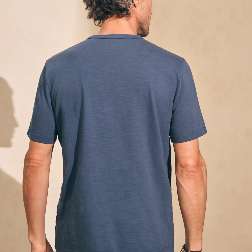 Back view of man wearing the short sleeve Sunwashed Tee in Dune Navy by Faherty