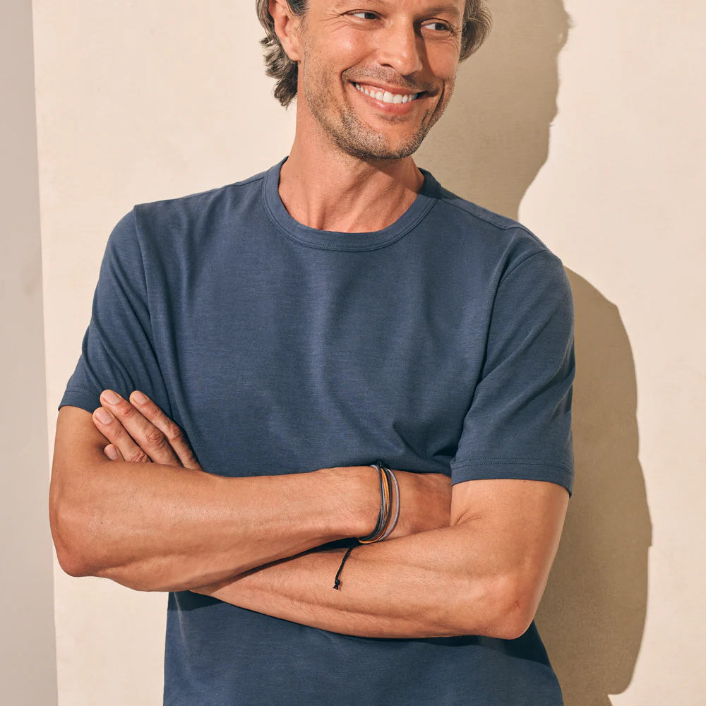 Front view of man wearing the short sleeve Sunwashed Tee in Dune Navy by Faherty
