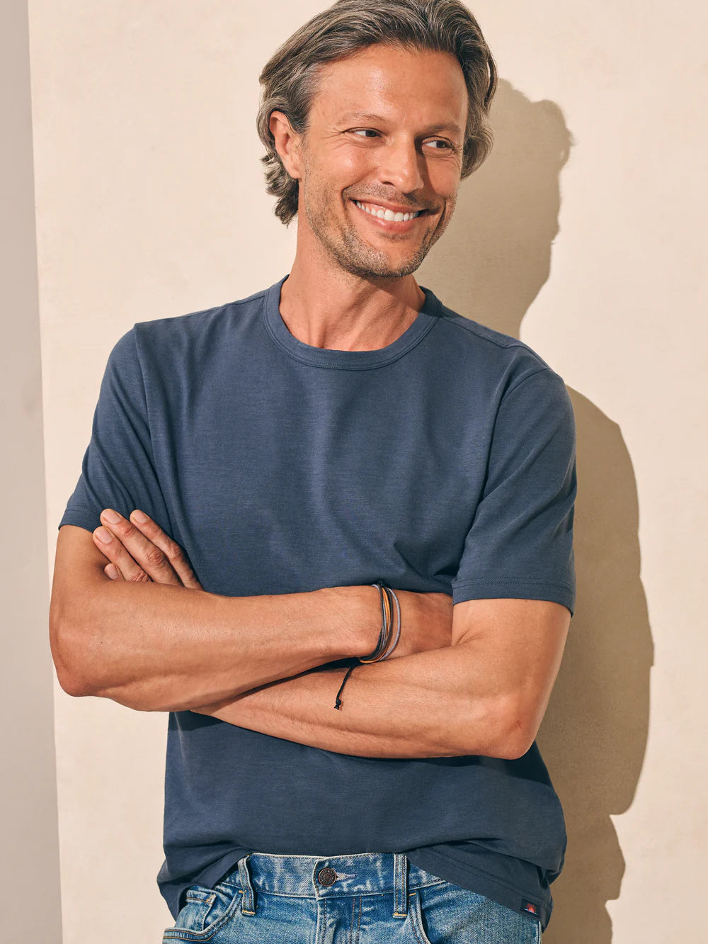 Front view of man wearing the short sleeve Sunwashed Tee in Dune Navy by Faherty