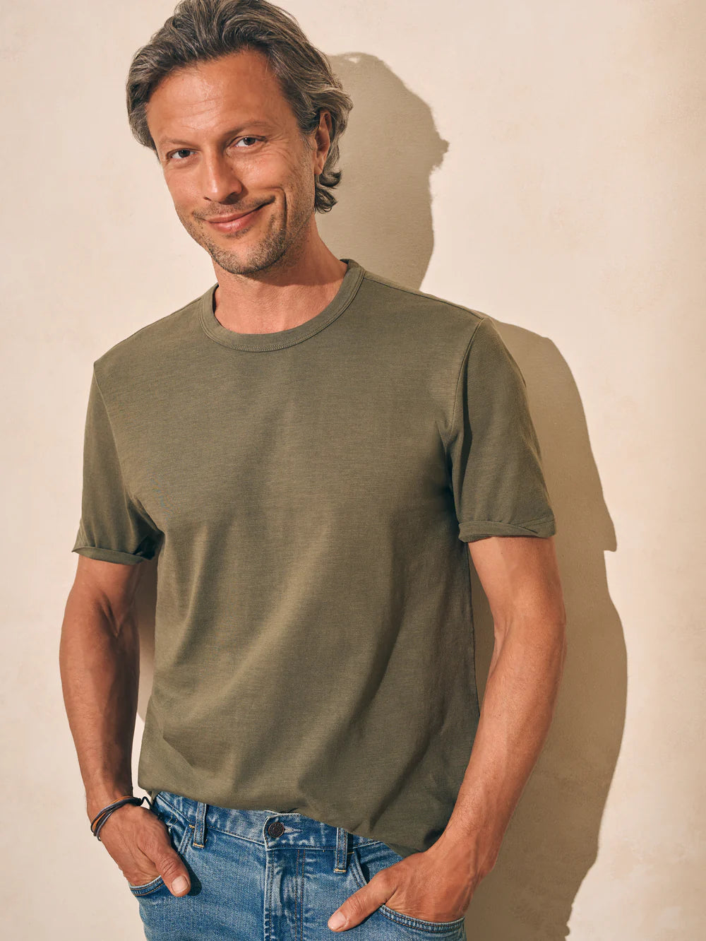 Front view of man wearing an olive green short sleeve t-shirt by Faherty