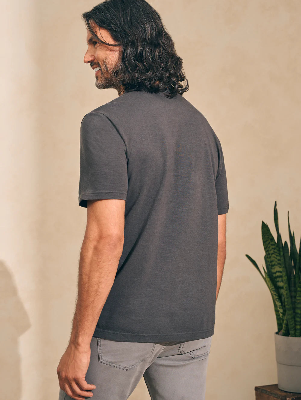 Back view of man wearing a washed black short sleeve t-shirt by Faherty