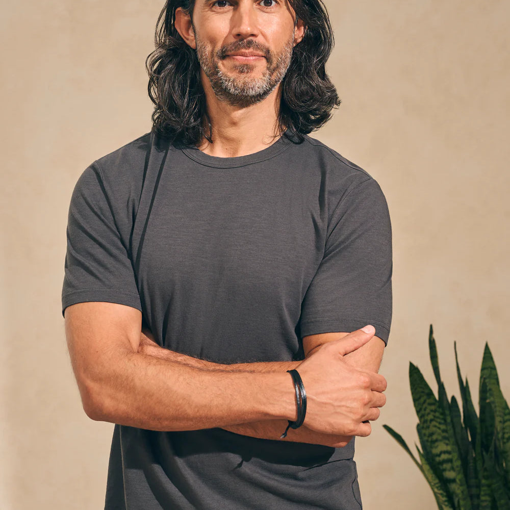 front view of man wearing a washed black short sleeve t-shirt by Faherty